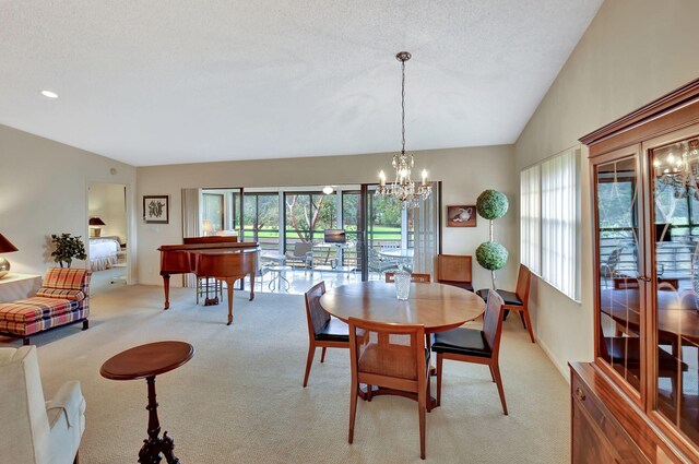 dining space with light carpet, plenty of natural light, lofted ceiling, and a chandelier