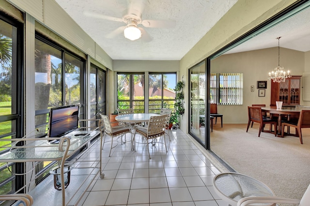 sunroom with ceiling fan with notable chandelier