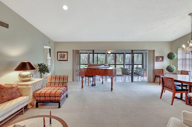 carpeted living room featuring a chandelier, vaulted ceiling, and a textured ceiling