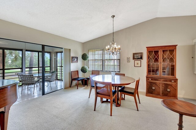 dining area with light carpet, a notable chandelier, lofted ceiling, and a textured ceiling