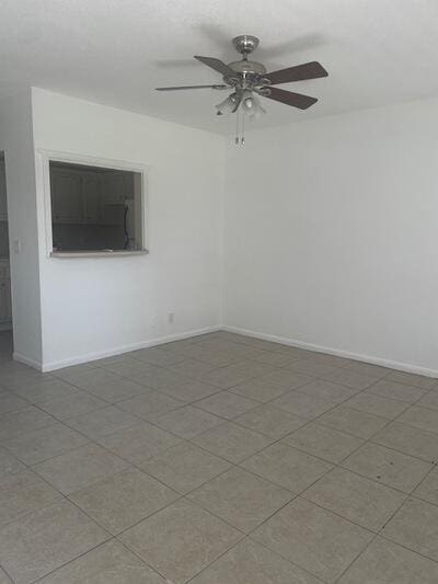 spare room featuring baseboards and a ceiling fan