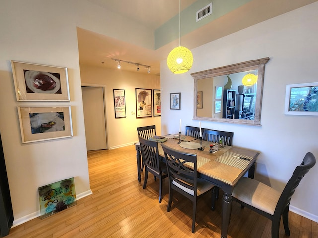 1551 N Flagler Dr Ph L7, West Palm Beach, FL 33401 - dining area featuring rail lighting, light wood-style floors, and baseboards