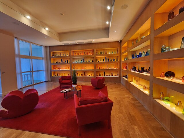 1551 N Flagler Dr Ph L7, West Palm Beach, FL 33401 - sitting room featuring built in shelves, light wood-type flooring, a tray ceiling, and recessed lighting