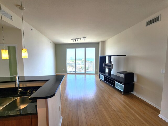 1551 N Flagler Dr Ph L7, West Palm Beach, FL 33401 - living room with light wood-style floors, baseboards, and rail lighting