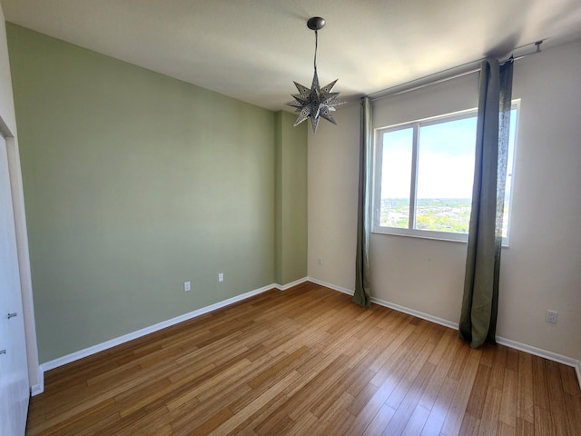 1551 N Flagler Dr Ph L7, West Palm Beach, FL 33401 - empty room featuring wood finished floors, baseboards, and a chandelier