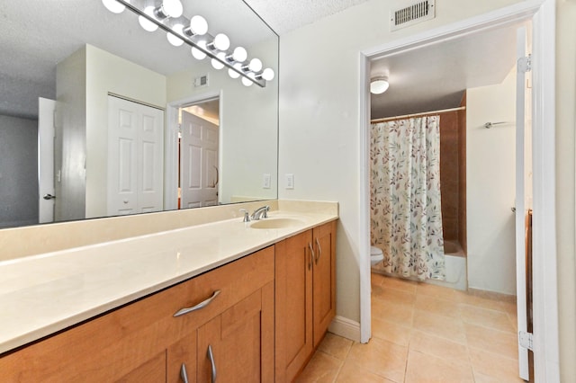 full bathroom with tile patterned flooring, vanity, toilet, a textured ceiling, and shower / bath combo with shower curtain