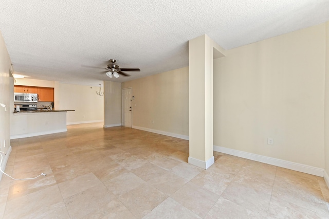 unfurnished living room featuring ceiling fan and a textured ceiling