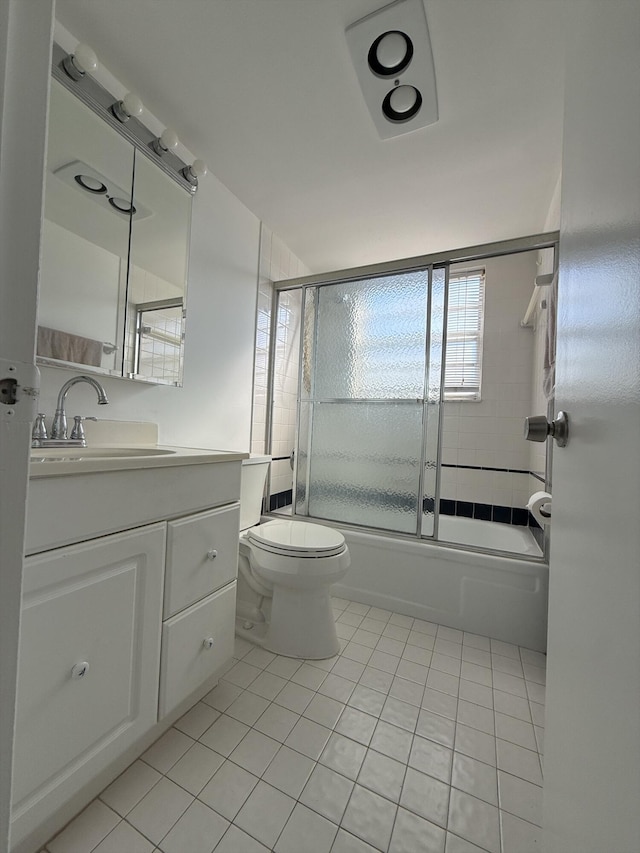 full bathroom featuring vanity, tile patterned floors, shower / bath combination with glass door, and toilet