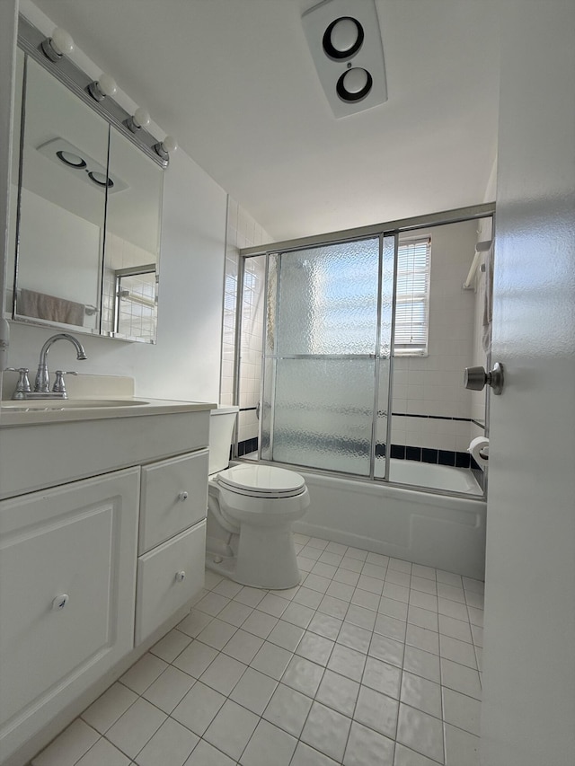 full bathroom with tile patterned flooring, vanity, shower / bath combination with glass door, and toilet