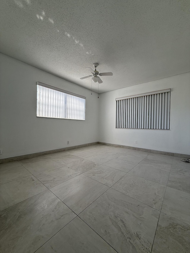 spare room featuring ceiling fan and a textured ceiling