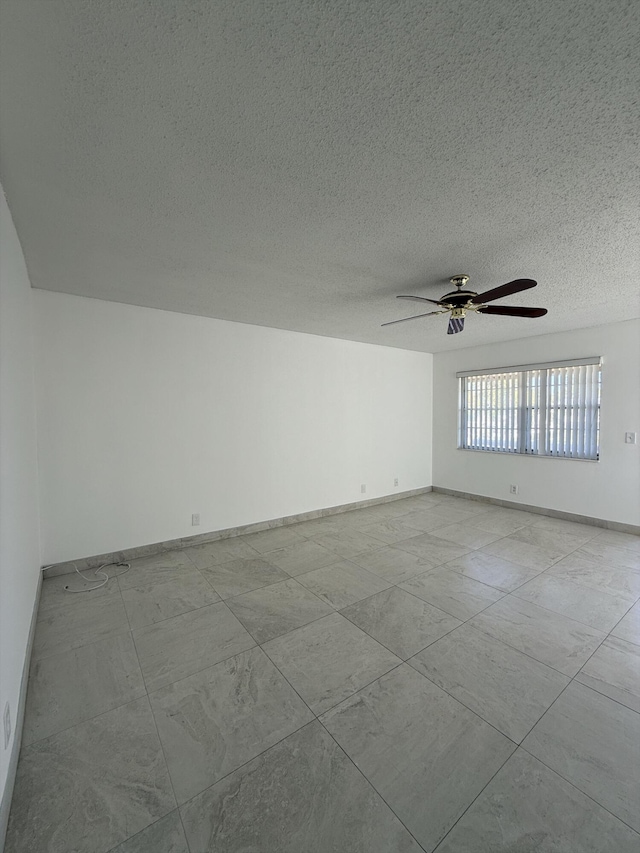 unfurnished room featuring ceiling fan and a textured ceiling