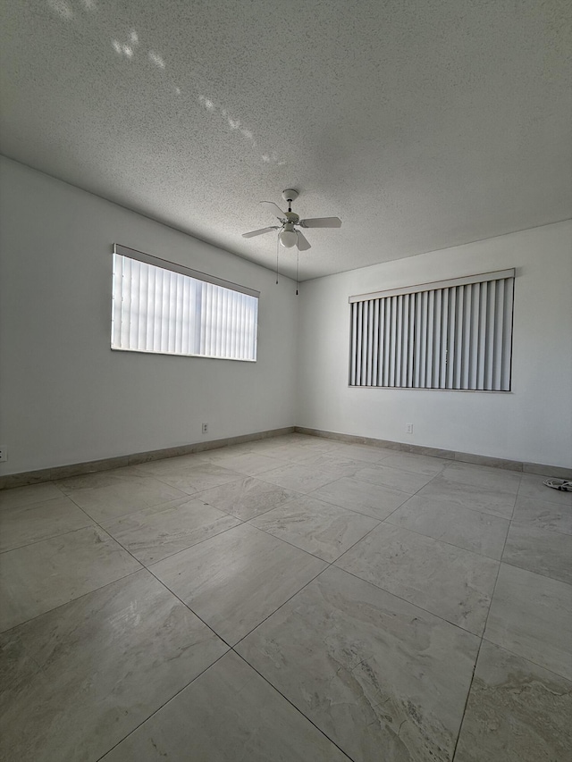 empty room featuring ceiling fan and a textured ceiling