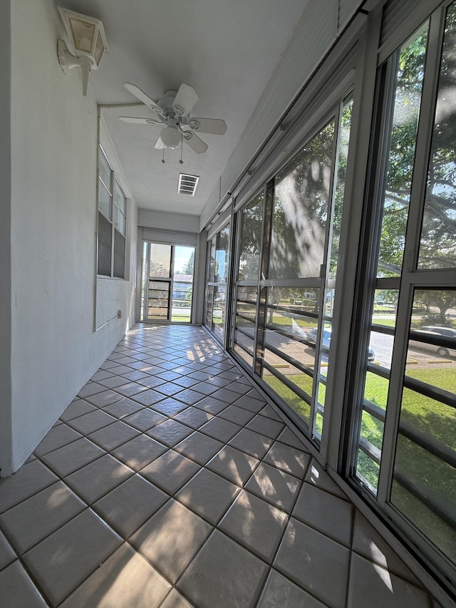 unfurnished sunroom with ceiling fan