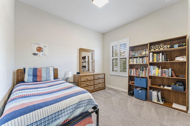 bedroom featuring light carpet and baseboards