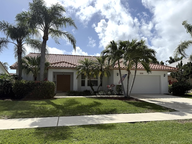 mediterranean / spanish-style home with a garage and a front lawn