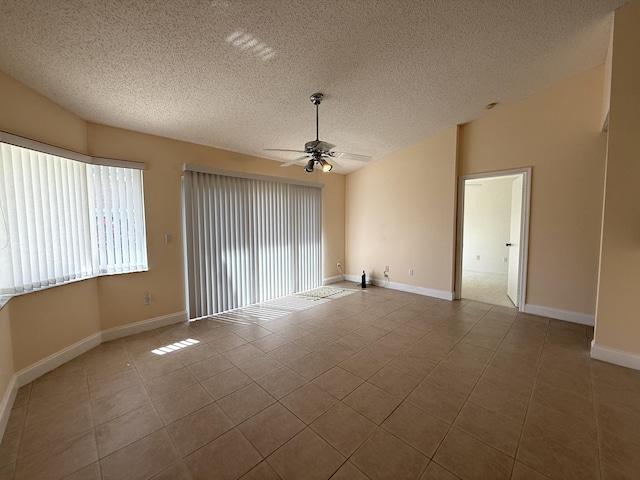 tiled spare room featuring a textured ceiling, vaulted ceiling, and ceiling fan