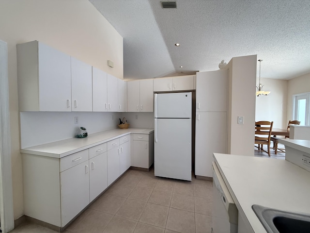 kitchen featuring lofted ceiling, white cabinets, white appliances, and decorative light fixtures