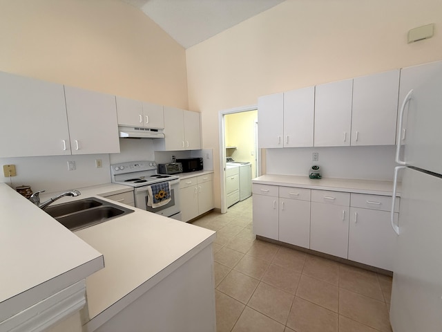 kitchen with sink, white appliances, washing machine and dryer, high vaulted ceiling, and white cabinets