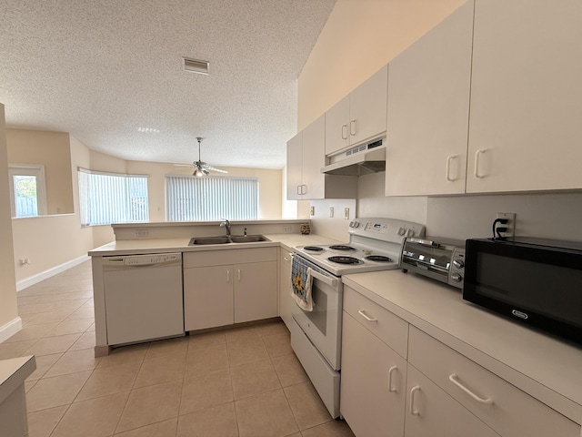 kitchen featuring light tile patterned flooring, sink, white appliances, and kitchen peninsula