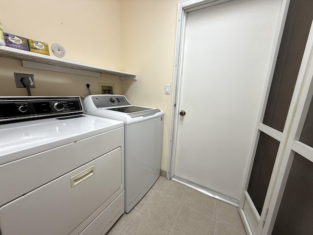 laundry room featuring independent washer and dryer and light tile patterned flooring