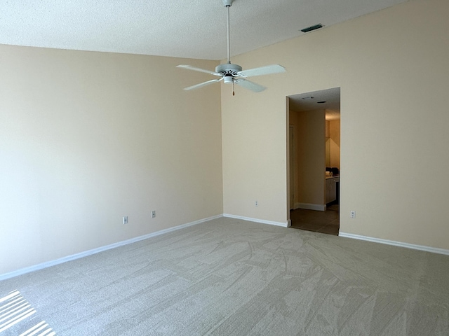 carpeted spare room with a textured ceiling and ceiling fan