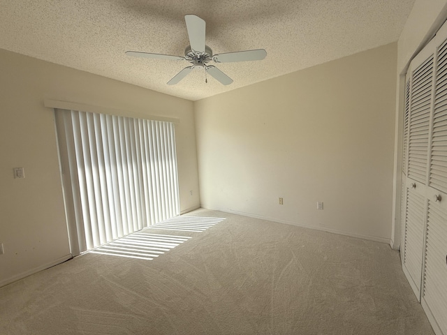 unfurnished bedroom featuring ceiling fan, carpet flooring, a textured ceiling, and a closet