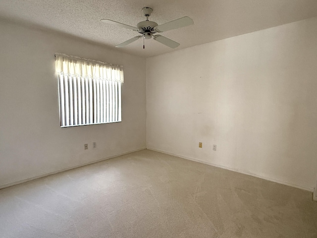 empty room featuring ceiling fan, carpet flooring, and a textured ceiling