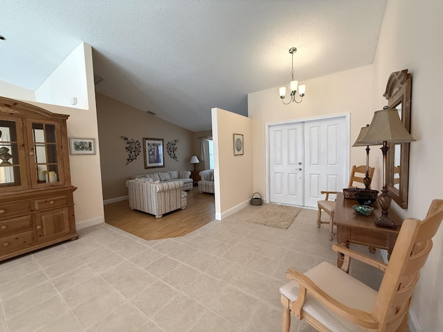 tiled entryway with lofted ceiling, a notable chandelier, and a textured ceiling