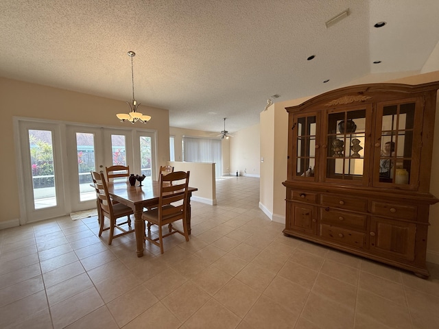 tiled dining room featuring a textured ceiling and a notable chandelier