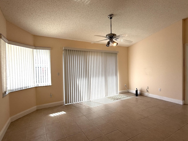 tiled empty room with vaulted ceiling, a textured ceiling, and ceiling fan