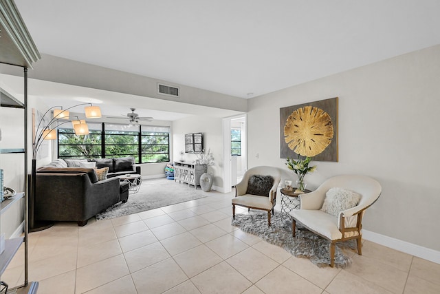 living room with a ceiling fan, visible vents, baseboards, and light tile patterned flooring