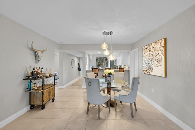 dining space featuring baseboards and light tile patterned flooring