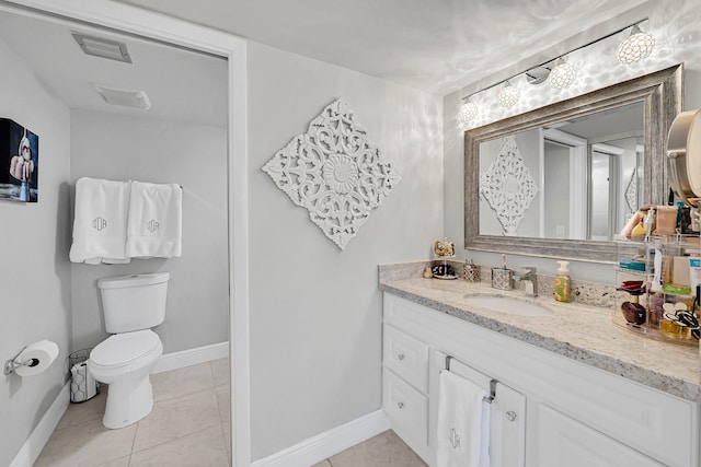 bathroom with toilet, vanity, baseboards, and tile patterned floors