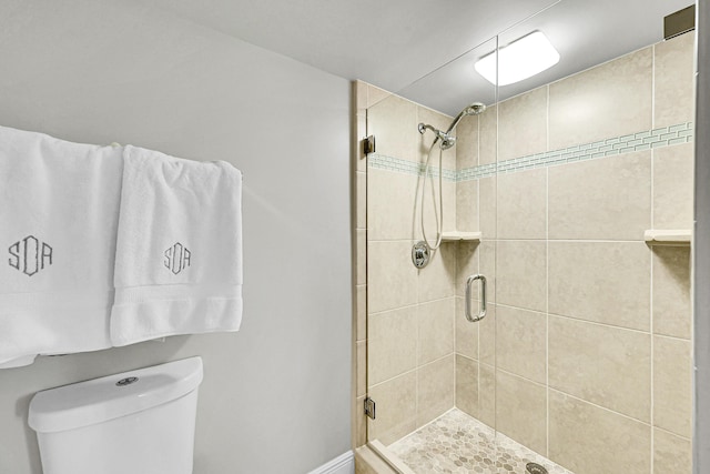 bathroom with a shower stall and toilet