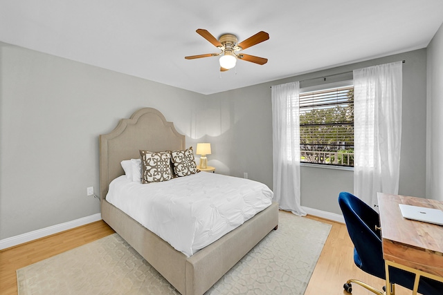 bedroom featuring light wood finished floors, ceiling fan, and baseboards