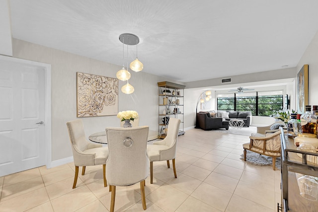 dining room featuring light tile patterned floors, ceiling fan, visible vents, and baseboards