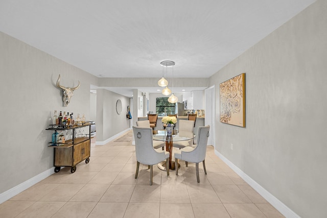 dining space with baseboards and light tile patterned flooring