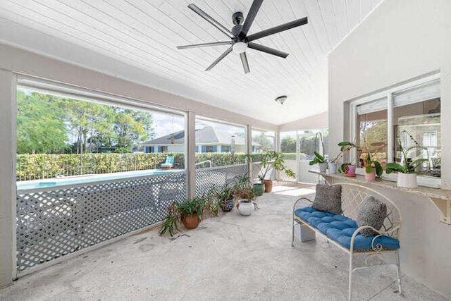 sunroom featuring lofted ceiling, plenty of natural light, wooden ceiling, and ceiling fan