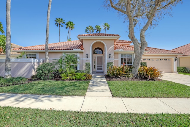 mediterranean / spanish-style home featuring a front lawn and a garage