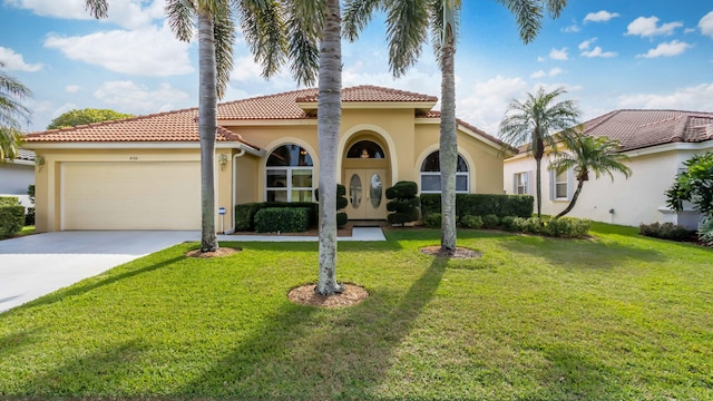 mediterranean / spanish house featuring a garage and a front yard