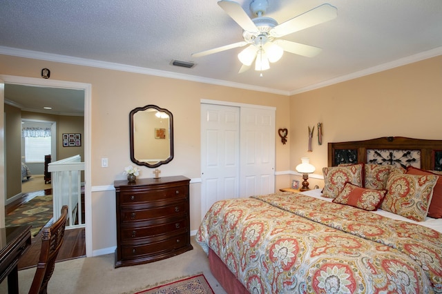 carpeted bedroom with crown molding, a textured ceiling, a closet, and ceiling fan