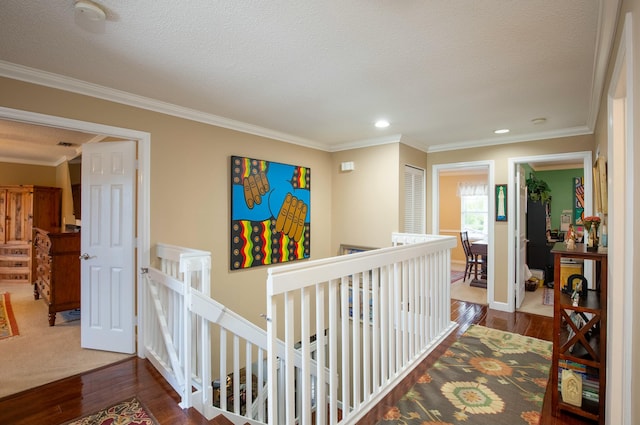 hall featuring hardwood / wood-style flooring, ornamental molding, and a textured ceiling