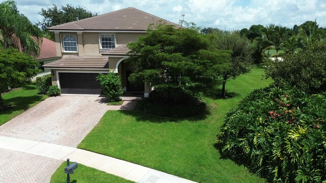 view of front of home with a garage and a front lawn