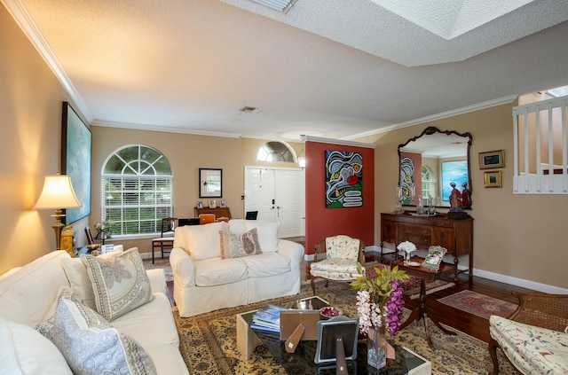 living room with crown molding, a skylight, and hardwood / wood-style floors