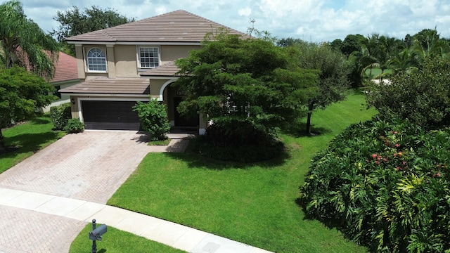 view of front of house with a garage and a front lawn