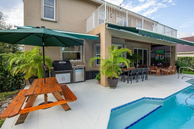 rear view of house featuring a patio, a balcony, and area for grilling