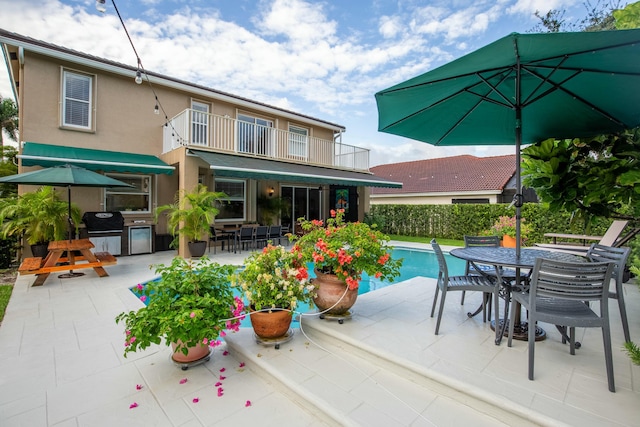 view of swimming pool with a patio, an outdoor kitchen, and a grill