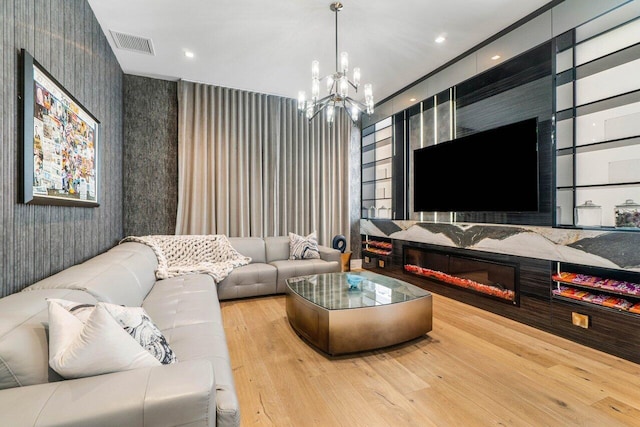 living area with a chandelier, recessed lighting, wood finished floors, visible vents, and wallpapered walls