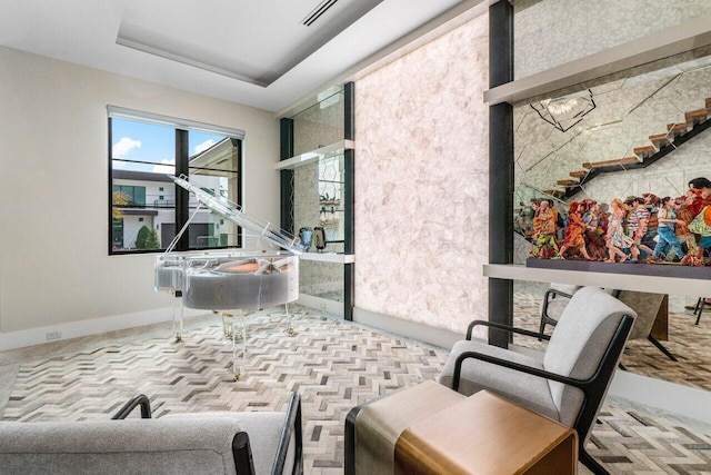 interior space featuring baseboards, visible vents, and a tray ceiling