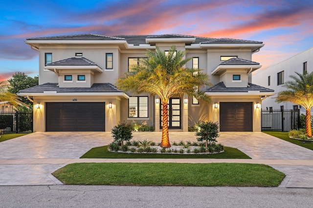 view of front of house with a garage, decorative driveway, and stucco siding